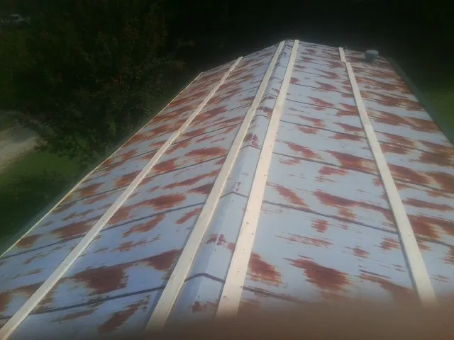 Rusted metal roof panels with new wood purlins before replacement — Storm Damage Roof Repair in Broussard by Roofing Brothers