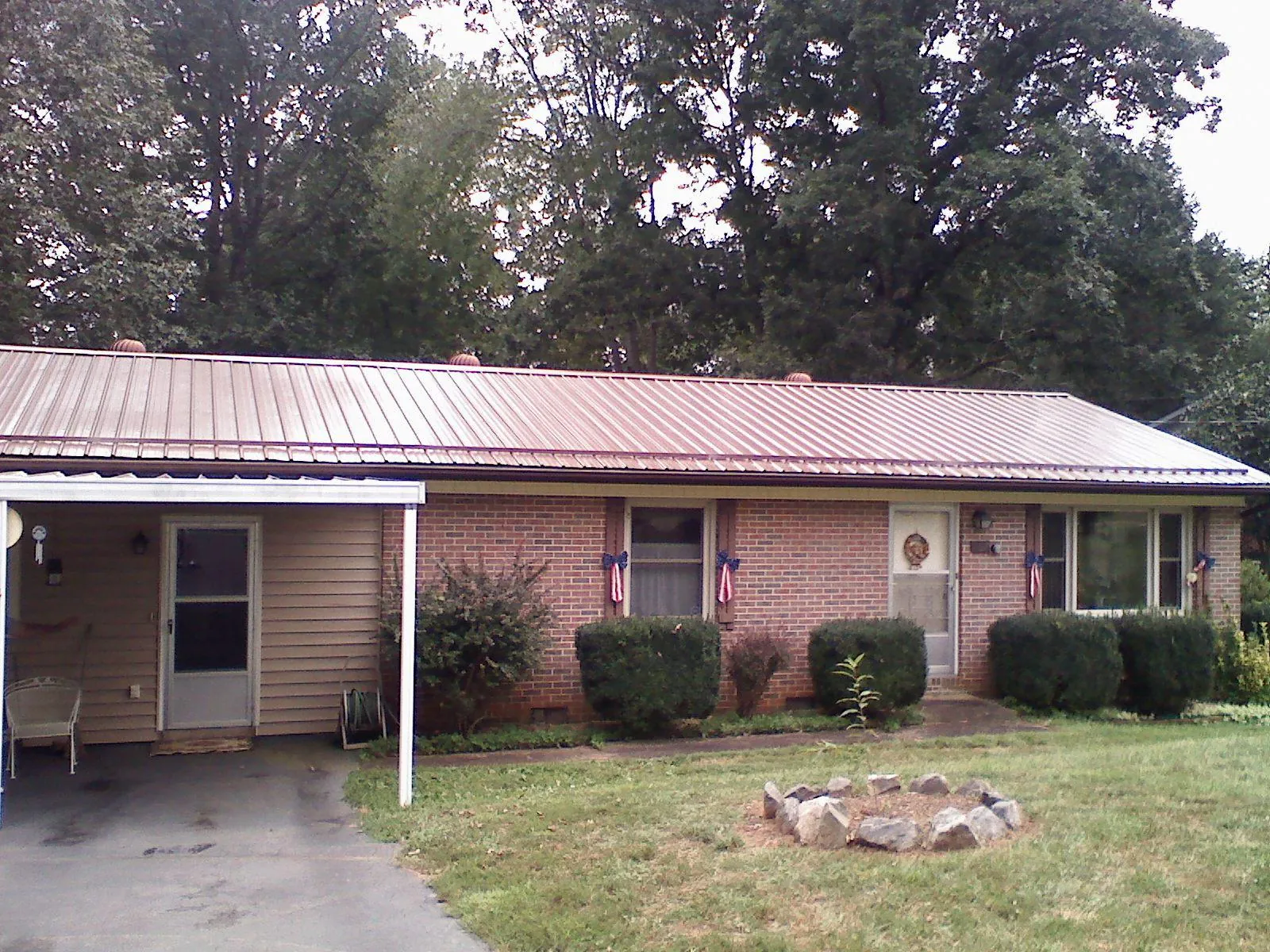 Bronze metal roof and carport on a brick ranch home — Roof Repair work by our crew in Broussard